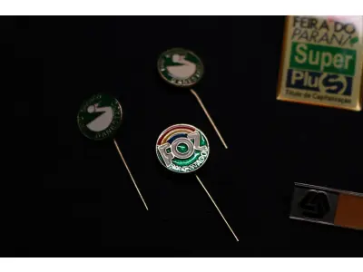 LOTE 045 - LOTE 45 – BANESTADO 	OBJETO	OBSERVAÇÕES 1.		Medalha Prateada Banestado – sem uso	3 unidades 2.		Medalha Associação Banestado – Inauguração Ginásio de Esportes-  30 de outubro de 1982	5 unidades 3.		Pin Banestado Feira do Paraná Super Plus Titulo de Capitalização.	3 unidades 4.		Pin CIN Centro Internacional de Negócios -  Banestado	1 unidade 5.		Pin 8ª Assembleia Geral da Federação Luterana Mundial – 1998 - Banestado	1 unidade 6.		Crachá de funcionário Banestado em metal	1 unidade 7.		Medalha Campeonato Paranaense de Natação – Associação Masters do Paraná. 2000. Banestado	1 unidade 8.		Medalha Honra ao Mérito - Banestado	1 unidade 9.		Alfinete de Lapela Banestado – Foz do Iguacu	1 unidade 10.		Alfinete de Lapela Banestado – Pato Branco	2 unidade