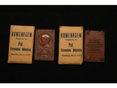 LOTE 020 - LOTE 20 – MEDALHAS FERNANDO MOREIRA 	MEDALHA	OBSERVAÇÕES 1.		Homenagem ao Professor Fernando Augusto Moreira. 1938. Gravador: José Peón	Acobreada - envelope original da medalha. 2.		Homenagem ao Professor Fernando Augusto Moreira. 1938. Gravador: José Peón	Acobreada - envelope original da medalha.