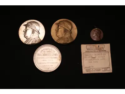 LOTE 042 - LOTE 42 – MEDALHAS DA REVOLUÇÃO DE 1932 	MEDALHA	OBSERVAÇÕES 1.		Medalhão – Soldados do General Waldomiro Lima. 1932. Gravador: José Peón.	Prateada 2.		Medalhão – Soldados do General Waldomiro Lima. 1932. Gravador: José Peón.	Prateada 3.		Medalhão – Soldados do General Waldomiro Lima. 1932. Gravador: José Peón.	Bronze 4.		Medalha Comemorativa da Campanha de 1932. Gravador: José Peón.	Acobreada – envelope da coleção Julio Estrella Moreira