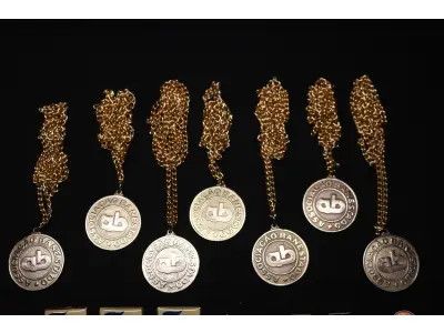 LOTE 046 - LOTE 46 – BANESTADO 	OBJETO	OBSERVAÇÕES 1.		Medalha Prateada Banestado – sem uso	3 unidades 2.		Medalha Associação Banestado – Inauguração Ginásio de Esportes-  30 de outubro de 1982	7 unidades 3.		Pin Banestado Feira do Paraná Super Plus Titulo de Capitalização.	3 unidades 4.		Pin CIN Centro Internacional de Negócios - Banestado	1 unidade 5.		Pin 8ª Assembleia Geral da Federação Luterana Mundial – 1998 - Banestado	2 unidades 6.		Crachá de funcionário Banestado em metal	1 unidade 7.		Chaveiro Banestado de metal e couro	1 unidade 8.		Alfinete de Lapela Banestado – Foz do Iguacu	1 unidade 9.		Alfinete de Lapela Banestado – Pato Branco	1 unidade