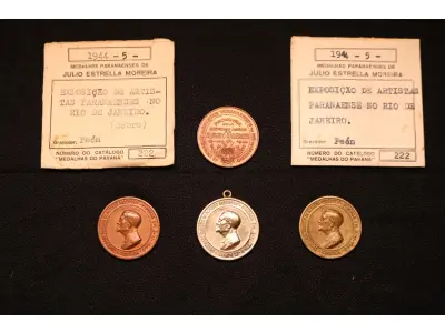 LOTE 011 - LOTE 11 – MEDALHAS – ALFREDO ANDERSEN 	MEDALHA	OBSERVAÇÕES 1.		1ª Exposição de Artistas Paranaenses no Rio de Janeiro. Sociedade de Amigos de Alfredo Andersen.1943. Gravador: José Peon	Cobre - envelope da Coleção Júlio Estrella Moreira 2.		1ª Exposição de Artistas Paranaenses no Rio de Janeiro. Sociedade de Amigos de Alfredo Andersen.1943. Gravador: José Peon	Cobre 3.		1ª Exposição de Artistas Paranaenses no Rio de Janeiro. Sociedade de Amigos de Alfredo Andersen.1943. Gravador: José Peon	Prateada - envelope da Coleção Júlio Estrella Moreira 4.		1ª Exposição de Artistas Paranaenses no Rio de Janeiro. Sociedade de Amigos de Alfredo Andersen.1943. Gravador: José Peon	Bronze - envelope da Coleção Júlio Estrella Moreira