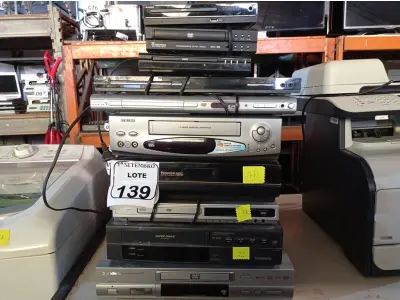 LOTE 139 - 02 VIDEOCASSETES E VÁRIOS APARELHOS DE DVDS MARCAS E MODELOS DIVERSOS. (NO ESTADO) ATENÇÃO! FAZER A VISITAÇÃO ANTES DE ARREMATAR, NÃO SABEMOS SE FUNCIONA. LEILÃO NÃO TEM GARANTIA E NEM DEVOLUÇÃO, SUJEITO A POSSÍVEIS AVARIAS VISÍVEIS/OCULTAS E/OU AUSÊNCIA DE COMPONENTES.