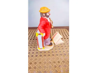 LOTE 205 - 01 ESTATUETA DE PALHAÇO DE CERÂMICA VINTAGE DA COLEÇÃO FLAMBRO DE EMMETT KELLY JR. PAÍS/REGIÃO DE FABRICAÇÃO TAIWAN. ESTA ESTATUETA DO EMMETT KELLY JR. APRESENTA UM PALHAÇO EMMETT KELLY JR. PALHAÇO COM COLEÇÃO HOBO TRUMPET ORIGINAL. EXCELENTE ESTADO, SEM LASCAS, RACHADURAS EM ÓTIMO ESTADO PEÇA RARA ITEM LANÇADOS ANOS 90 NOS EUA  CM DE ALTURA E UMA BASE DE 15 ​​CM. COM  SUA ASSINATURA NA PARTE INFERIOR JUNTO COM "EXCLUSIVAMENTE DA FLAMBRO EMPRESA FAMOSA NOS EUA DECADA DE 90, COMPRADAS EM LOJAS DE ANTIGUIDADES DOS EUA. (NO ESTADO) ATENÇÃO! FAZER A VISITAÇÃO ANTES DE ARREMATAR, NÃO SABEMOS SE FUNCIONA, LEILÃO NÃO TEM GARANTIA E NEM DEVOLUÇÃO, SUJEITO A POSSÍVEIS AVARIAS VISÍVEIS/OCULTAS E/OU AUSÊNCIA DE COMPONENTES.