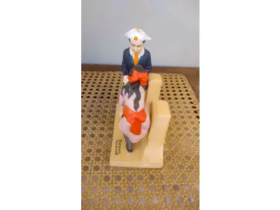 LOTE 207 - 01 ESTATUETA VINTAGE DE NORMAN ROCKWELL FEITA NO JAPÃO, BELA ESTATUETA DE PORCELANA RETRATA UMA MENINA E UM MENINO EM SUA PRIMEIRA DANÇA. CRIADA PELO RENOMADO ARTISTA NORMAN ROCKWELL, ESTA PEÇA É UMA REPRODUÇÃO LICENCIADA DO FINAL DO SÉCULO XX. MEDINDO 12 CM DE COMPRIMENTO E MENOS DE 16 CM DE ALTURA, É UMA ESTATUETA DE TAMANHO MÉDIO QUE SERIA UMA ÓTIMA ADIÇÃO A QUALQUER AMBIENTE. A ESTATUETA É FEITA À MÃO COM ACABAMENTO EM PINTURA E APRESENTA DETALHES MULTICOLORIDOS. É UMA PEÇA DE ESTILO MODERNO QUE APRESENTA FIGURAS HISTÓRICAS E É PERFEITA PARA COLECIONADORES, FOI PRODUZIDA NO JAPÃO COM TÉCNICAS DE PRODUÇÃO PROFISSIONAL.COMPRADAS EM LOJAS DE ANTIGUIDADES DOS EUA. OBS PEÇA COM RESTAURO. (NO ESTADO) ATENÇÃO! FAZER A VISITAÇÃO ANTES DE ARREMATAR, NÃO SABEMOS SE FUNCIONA, LEILÃO NÃO TEM GARANTIA E NEM DEVOLUÇÃO, SUJEITO A POSSÍVEIS AVARIAS VISÍVEIS/OCULTAS E/OU AUSÊNCIA DE COMPONENTES.