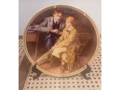 LOTE 228 - 01 RARO PRATO DE NORMAN ROCKWELL "CONFIANDO NA TOCA" EM INGLÊS "CONFIDING IN THE DEN"  PEÇA DE COLECIONADOR  VINTAGE NORMAN ROCKWELL "CONFIANDO NA TOCA" COM DETALHES EM OURO 24K. PRATO NUMERADO DE PORCELANA FINA EDWIN M. KNOWLES. EDIÇÃO LIMITADA NUMERADA 15298B E DATA DA COMPRA EM 17/03/1984DE NORMAN ROCKWELL, DÉCIMA PRIMEIRA EDIÇÃO DA COLEÇÃO MULHERES REDESCOBERTAS DE ROCKWELL, FEITA EM UMA EDIÇÃO ESTRITAMENTE LIMITADA A CEM DIAS DE QUEIMA E CERTIFICADA COMO UM "VERDADEIRO CLÁSSICO ROCKWELL" PELA ROCKWELL SOCIETY OF AMERICA. COM CERTIFICADO DE AUTENTICIDADE  DOCUMENTOS E NOTRA DE COMPRA E  DATADA EM 17/03/1984 E CAIXA ORIGINAL. O PRATO MEDE 21,5 CM DE DIÂMETRO. ITEM COMPRADO EM GARAGENS DE ANTIGUIDADES NOS EUA. SUPORTE PARA PRATO NÃO INCLUÍDO NESTA VENDA. (NO ESTADO) ATENÇÃO! FAZER A VISITAÇÃO ANTES DE ARREMATAR, NÃO SABEMOS SE FUNCIONA, LEILÃO NÃO TEM GARANTIA E NEM DEVOLUÇÃO, SUJEITO A POSSÍVEIS AVARIAS VISÍVEIS/OCULTAS E/OU AUSÊNCIA DE COMPONENTES.