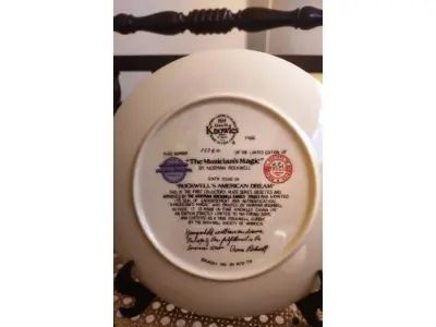 LOTE 206 - 01 BELO PRATO COLECIONÁVEL DA EDWIN M. KNOWLES CHINA COMPANY. ESTE PRATO SE CHAMA "A MAGIA DO MÚSICO" E FAZ PARTE DA COLEÇÃO "O SONHO AMERICANO DE ROCKWELL". É UMA EDIÇÃO LIMITADA, COM O NÚMERO DE PRATO 1334 C, E FOI CRIADO EM 1986. FOI PROJETADO PELO FAMOSO ARTISTA NORMAN ROCKWELL E É O SEXTO DA SÉRIE MENCIONADA ACIMA. ACOMPANHA O CERTIFICADO DE AUTENTICIDADE ORIGINAL E CARIMBO DE AUTENTICIDADE NO PRATO E OS DEMAIS DOCUMENTOS QUE VOCÊ VÊ NAS FOTOS. O PRATO TEM UM DIÂMETRO DE 21,8 CM. A EMBALAGEM ORIGINAL.O SUPORTE DO PRATO NÃO ESTÁ INCLUÍDO. (NO ESTADO) ATENÇÃO! FAZER A VISITAÇÃO ANTES DE ARREMATAR, NÃO SABEMOS SE FUNCIONA, LEILÃO NÃO TEM GARANTIA E NEM DEVOLUÇÃO, SUJEITO A POSSÍVEIS AVARIAS VISÍVEIS/OCULTAS E/OU AUSÊNCIA DE COMPONENTES.