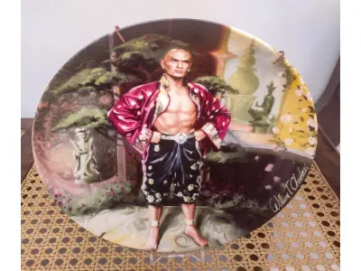 LOTE 017 - 01 ADORADO PRATO DE COLECIONADOR INTITULADO "UM ENIGMA" É UM PRATO DE COLECIONADOR DE EDIÇÃO LIMITADA DA SÉRIE  "THE KING AND" "EM PORTUGUES O REI E EU", DE KNOWLES.PINTADO À MÃO POR WILLIAM CHAMBERS. VENDIDO APENAS POR 150 DIAS E LOGO FOI ENCERRADA AS VENDAS NOS EUA.COM NOTA DE COMPRA DATADA EM 27/07/1984 EM 1980.O PRATO MEDE APROXIMADAMENTE 21 CM E ESTÁ EM EXCELENTE ESTADO.NÚMERO DO PRATO: 19725G.COM CAIXA E CERTIFICADO, MANTIDO EM CASA LIVRE DE FUMO.PEÇA COMPRADA EM GARAGEM DE ANTIGUIDADES NOS EUA. “SUPORTE PARA PRATO NÃO INCLUÍDO NESTA VENDA.”ITEM COMPRADO EM GARAGENS DE ANTIGUIDADES NOS EUA. (NO ESTADO) ATENÇÃO! FAZER A VISITAÇÃO ANTES DE ARREMATAR, NÃO SABEMOS SE FUNCIONA, LEILÃO NÃO TEM GARANTIA E NEM DEVOLUÇÃO, SUJEITO A POSSÍVEIS AVARIAS VISÍVEIS/OCULTAS E/OU AUSÊNCIA DE COMPONENTES.