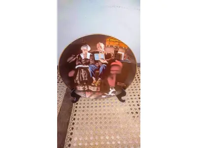 LOTE 232 - 01 BELO PRATO NORMAN ROCKWELL COM 21,5 CM DE DIÂMETRO APRESENTA A ICÔNICA OBRA DE ARTE DE NORMAN ROCKWELL INTITULADA "EVENING'S EASE". FABRICADO NOS ESTADOS UNIDOS DURANTE A DÉCADA DE 1980, ESTE PRATO MULTICOLORIDO RETRATA A CENA SERENA DE UMA MULHER DESFRUTANDO DE UM MOMENTO DE PAZ EM SUA VARANDA. UMA ÓTIMA ADIÇÃO A QUALQUER COLEÇÃO DE ITENS DECORATIVOS COLECIONÁVEIS. FEITO EM UMA EDIÇÃO ESTRITAMENTE LIMITADA A 50 DIAS DE QUEIMA NOS EUA. POR KNOWLES, O NOME MAIS ANTIGO DA AMÉRICA EM FINE PORCELANA CHINA. ITEM DE COLECIONADOR, CAIXA ORIGINAL E COM CERTIFICADO DE AUTENTICIDADE. SUPORTE PARA PRATO NÃO INCLUÍDO NESTA VENDA. (NO ESTADO) ATENÇÃO! FAZER A VISITAÇÃO ANTES DE ARREMATAR, NÃO SABEMOS SE FUNCIONA, LEILÃO NÃO TEM GARANTIA E NEM DEVOLUÇÃO, SUJEITO A POSSÍVEIS AVARIAS VISÍVEIS/OCULTAS E/OU AUSÊNCIA DE COMPONENTES.
