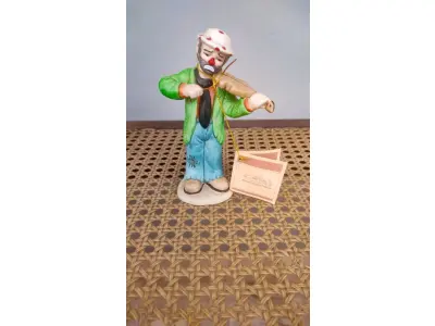 LOTE 203 - 01 ESTATUETA DE PALHAÇO DE CERÂMICA VINTAGE DA COLEÇÃO FLAMBRO DE EMMETT KELLY JR. PAÍS/REGIÃO DE FABRICAÇÃO TAIWAN. ESTA ESTATUETA DO EMMETT KELLY JR. APRESENTA UM PALHAÇO EMMETT KELLY JR. PALHAÇO  TOCANDO VIOLINO ORIGINAL. EXCELENTE ESTADO, SEM LASCAS, RACHADURAS EM ÓTIMO ESTADO PEÇA RARA ITEM LANÇADOS ANOS 90 NOS EUA  CM DE ALTURA E UMA BASE DE 15 ​​CM. COM  SUA ASSINATURA NA PARTE INFERIOR JUNTO COM "EXCLUSIVAMENTE DA FLAMBRO EMPRESA FAMOSA NOS EUA DECADA DE 90, COMPRADAS EM LOJAS DE ANTIGUIDADES DOS EUA. (NO ESTADO) ATENÇÃO! FAZER A VISITAÇÃO ANTES DE ARREMATAR, NÃO SABEMOS SE FUNCIONA, LEILÃO NÃO TEM GARANTIA E NEM DEVOLUÇÃO, SUJEITO A POSSÍVEIS AVARIAS VISÍVEIS/OCULTAS E/OU AUSÊNCIA DE COMPONENTES.