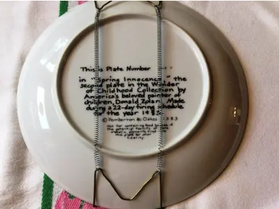 LOTE 028 - 01 PRATO DE COLECIONADOR DONALD ZOLAN “SPRING INNOCENCE” MARAVILHA DA INFÂNCIA 1983 CAIXA COA. LINDA PEÇA , COM CORES MARAVILHOSAS. ESTE BELO PRATO DE COLECIONADOR DA PEMBERTON & OAKE APRESENTA A ARTE DE DONALD ZOLAN. O PRATO, INTITULADO "SPRING INNOCENCE", RETRATA UMA CRIANÇA COM UM BUQUÊ DE FLORES EM FORMATO REDONDO. O PRATO É FEITO DE PORCELANA E MEDE 21,5 CM DE DIÂMETRO. ACOMPANHA UM CERTIFICADO DE AUTENTICIDADE E ESTÁ ACONDICIONADO EM SUA CAIXA ORIGINAL.                                                                                A PEÇA VINTAGE FOI PRODUZIDA NO FINAL DO SÉCULO XX COM UM ESTILO DE PRODUÇÃO DE CERÂMICA ARTÍSTICA COMPRADO EM GARAGEM DE ANTIGUIDADES NOS EUA.SUPORTE PARA PRATO NÃO INCLUÍDO NESTA VENDA. (NO ESTADO) ATENÇÃO! FAZER A VISITAÇÃO ANTES DE ARREMATAR, NÃO SABEMOS SE FUNCIONA, LEILÃO NÃO TEM GARANTIA E NEM DEVOLUÇÃO, SUJEITO A POSSÍVEIS AVARIAS VISÍVEIS/OCULTAS E/OU AUSÊNCIA DE COMPONENTES.