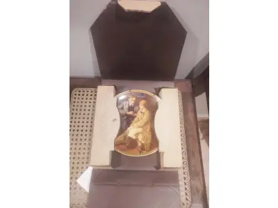 LOTE 228 - 01 RARO PRATO DE NORMAN ROCKWELL "CONFIANDO NA TOCA" EM INGLÊS "CONFIDING IN THE DEN"  PEÇA DE COLECIONADOR  VINTAGE NORMAN ROCKWELL "CONFIANDO NA TOCA" COM DETALHES EM OURO 24K. PRATO NUMERADO DE PORCELANA FINA EDWIN M. KNOWLES. EDIÇÃO LIMITADA NUMERADA 15298B E DATA DA COMPRA EM 17/03/1984DE NORMAN ROCKWELL, DÉCIMA PRIMEIRA EDIÇÃO DA COLEÇÃO MULHERES REDESCOBERTAS DE ROCKWELL, FEITA EM UMA EDIÇÃO ESTRITAMENTE LIMITADA A CEM DIAS DE QUEIMA E CERTIFICADA COMO UM "VERDADEIRO CLÁSSICO ROCKWELL" PELA ROCKWELL SOCIETY OF AMERICA. COM CERTIFICADO DE AUTENTICIDADE  DOCUMENTOS E NOTRA DE COMPRA E  DATADA EM 17/03/1984 E CAIXA ORIGINAL. O PRATO MEDE 21,5 CM DE DIÂMETRO. ITEM COMPRADO EM GARAGENS DE ANTIGUIDADES NOS EUA. SUPORTE PARA PRATO NÃO INCLUÍDO NESTA VENDA. (NO ESTADO) ATENÇÃO! FAZER A VISITAÇÃO ANTES DE ARREMATAR, NÃO SABEMOS SE FUNCIONA, LEILÃO NÃO TEM GARANTIA E NEM DEVOLUÇÃO, SUJEITO A POSSÍVEIS AVARIAS VISÍVEIS/OCULTAS E/OU AUSÊNCIA DE COMPONENTES.