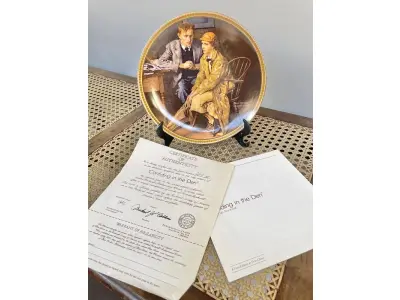 LOTE 074 - 01 RARO PRATO DE NORMAN ROCKWELL "CONFIANDO NA TOCA" PEÇA DE COLECIONADOR VINTAGE NORMAN ROCKWELL " EM INGLÊS "CONFIDING IN THE DEN" COM DETALHES EM OURO 24K. PRATO NUMERADO DE PORCELANA FINA EDWIN M. KNOWLES. EDIÇÃO LIMITADA DE NORMAN ROCKWELL, DÉCIMA PRIMEIRA EDIÇÃO DA COLEÇÃO MULHERES REDESCOBERTAS DE ROCKWELL, FEITA EM UMA EDIÇÃO ESTRITAMENTE LIMITADA A CEM DIAS DE QUEIMA E CERTIFICADA COMO UM "VERDADEIRO CLÁSSICO ROCKWELL" PELA ROCKWELL SOCIETY OF AMERICA. COM CERTIFICADO DE AUTENTICIDADE E CAIXA ORIGINAL. O PRATO MEDE 21,5 CM DE DIÂMETRO. SUPORTE PARA PRATO NÃO INCLUÍDO NESTA VENDA. (NO ESTADO) ATENÇÃO! FAZER A VISITAÇÃO ANTES DE ARREMATAR, NÃO SABEMOS SE FUNCIONA, LEILÃO NÃO TEM GARANTIA E NEM DEVOLUÇÃO, SUJEITO A POSSÍVEIS AVARIAS VISÍVEIS/OCULTAS E/OU AUSÊNCIA DE COMPONENTES.