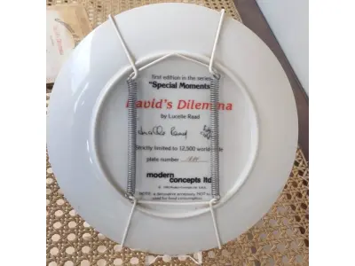 LOTE 014 - 01 RARO PRATO "DAVID'S DILEMMA" "EM PORTUGUES O DILEMA DE DAVID".VINTAGE DE 1982, MOMENTOS ESPECIAIS DE LUCELLE RAAD,4ª EDIÇÃO DA SÉRIE "MOMENTOS ESPECIAIS" CONCEITOS MODERNOS DE 1984,LIMITADO A APENAS 12.500 CÓPIAS EM TODO O MUNDO Nº DO PRATO E 1834, ESTE PRATO DE COLECIONADOR DA MODERN CONCEPTS, LTD. É UMA BELA ADIÇÃO A QUALQUER COLEÇÃO. O PRATO APRESENTA UM DESIGN COLORIDO, FORMATO REDONDO E 21,5 CM DE DIÂMETRO. FOI FEITO EM PORCELANA NO FINAL DO SÉCULO XX, ESPECIFICAMENTE EM 1984. O PRATO FAZ PARTE DA SÉRIE SECRETS SPECIAL MOMENTS, CRIADA POR LUCELLE RAAD, E TEM COMO TEMA CRIANÇAS. É UM ITEM VINTAGE E FOI FABRICADO NOS ESTADOS UNIDOS. ESTE PRATO DECORATIVO DE COLECIONADOR É PERFEITO PARA TODAS AS OCASIÕES E SERIA UM ÓTIMO COMPLEMENTO PARA QUALQUER DECORAÇÃO. EM EXCELENTE ESTADO, POSSUI A CAIXA ORIGINAL CERTIFICADO DE AUTENTICIDADE E OS DOCUMENTOS. O SUPORTE DO PRATO NÃO ESTÁ INCLUÍDO. PEÇA COMPRADA EM GARAGEM DE ANTIGUIDADES NOS EUA. (NO ESTADO) ATENÇÃO! FAZER A VISITAÇÃO ANTES DE ARREMATAR, NÃO SABEMOS SE FUNCIONA, LEILÃO NÃO TEM GARANTIA E NEM DEVOLUÇÃO, SUJEITO A POSSÍVEIS AVARIAS VISÍVEIS/OCULTAS E/OU AUSÊNCIA DE COMPONENTES.