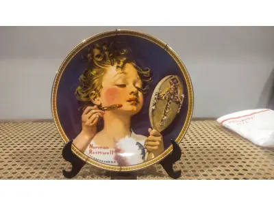 01 RARO PRATO PARA AMANTES E COLECIONADORES DE NORMAN ROCKWELL! ESTE É UM PRATO COLECIONÁVEL DE PORCELANA VINTAGE DE EDIÇÃO LIMITADA. "MAKING BELIEVE AT THE MIRROR" É A QUARTA PLACA DA COLEÇÃO DE EDIÇÃO LIMITADA INTITULADA ROCKWELL'S REDISCOVERED WOMEN, UMA SÉRIE QUE OFERECE UMA RETROSPECTIVA ÚNICA DAS OBRAS DE NORMAN ROCKWELL. ESTA OBRA É OFICIALMENTE CERTIFICADA PELA ROCKWELL SOCIETY OF AMERICA. FOI ENCONTRADA EM UM ARMÁRIO DURANTE A VENDA DE UMA PROPRIEDADE, APÓS MUITOS ANOS GUARDADA.  CAIXA ORIGINAL E CERTIFICADO DE AUTENTICIDADE DA PEÇA  O PRATO MEDE 21,5 CM DE DIÂMETRO.  SUPORTE PARA PRATO NÃO INCLUÍDO NESTA VENDA. (NO ESTADO) ATENÇÃO! FAZER A VISITAÇÃO ANTES DE ARREMATAR, NÃO SABEMOS SE FUNCIONA, LEILÃO NÃO TEM GARANTIA E NEM DEVOLUÇÃO, SUJEITO A POSSÍVEIS AVARIAS VISÍVEIS/OCULTAS E/OU AUSÊNCIA DE COMPONENTES.