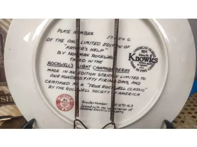 LOTE 090 - 01 RARO PRATO DE NORMAN ROCKWELL COM21 CM DE DIÂMETRO. A PRIMEIRA EDIÇÃO LIMITADA "FATHER'S HELP" DE CERTIFICADO COMO UM "VERDADEIRO CLÁSSICO ROCKWELL" PELA ROCKWELL SOCIETY OF AMERICA.FEITO EM UMA EDIÇÃO ESTRITAMENTE LIMITADA A 150 DIAS DE QUEIMA NOS EUA. POR KNOWLES, O NOME MAIS ANTIGO DA AMÉRICA EM FINE PORCELANA CHINA. ITEM DE COLECIONADOR DA SÉRIE LIGHT CAMPAIGN DE NORMAN ROCKWELL. ESTE PRATO VINTAGE DO FINAL DO SÉCULO XX (1980-1989) APRESENTA O CLÁSSICO DESIGN "AJUDA DO PAI" E FOI FABRICADO NOS ESTADOS UNIDOS. ITEM FOI ENCONTRADO EM UM ARMÁRIO DURANTE A VENDA DE UMA PROPRIEDADE NOS EUA APÓS MUITOS ANOS GUARDADOS.  CAIXA “ORIGINAL E COM CERTIFICADO DE AUTENTICIDADE, SUPORTE PARA PRATO NÃO INCLUÍDO NESTA VENDA. (NO ESTADO) ATENÇÃO! FAZER A VISITAÇÃO ANTES DE ARREMATAR, NÃO SABEMOS SE FUNCIONA, LEILÃO NÃO TEM GARANTIA E NEM DEVOLUÇÃO, SUJEITO A POSSÍVEIS AVARIAS VISÍVEIS/OCULTAS E/OU AUSÊNCIA DE COMPONENTES.