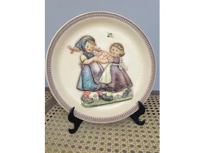 LOTE 244 - 01 RARO E DIFERENCIADO  PRATO DE EDIÇÃO DE  ANIVERSÁRIO DE GOEBEL M.J. HUMMEL, 1980, "SPRING DANCE", 25 CM - PERFEITO, NA CAIXA ORIGINAL. E COM SEUS FOLHETOS ORIGINAIS ESTE FOI FABRICADO NA ALEMANHA OCIDENTAL. O PRATO TEM 25 CM DE DIÂMETRO E ESTÁ EM PERFEITAS CONDIÇÕES. GUARDADOS HÁ ANOS. ITEM COMPRADO E GARAGENS DE ANTIGUIDADES NOS EUA. SUPORTE PARA PRATO NÃO INCLUÍDO NESTA VENDA. (NO ESTADO) ATENÇÃO! FAZER A VISITAÇÃO ANTES DE ARREMATAR, NÃO SABEMOS SE FUNCIONA, LEILÃO NÃO TEM GARANTIA E NEM DEVOLUÇÃO, SUJEITO A POSSÍVEIS AVARIAS VISÍVEIS/OCULTAS E/OU AUSÊNCIA DE COMPONENTES.