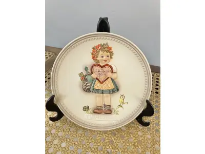 01 RARO PRATO DE PORCELANA LINDAMENTE TRABALHADO DA FAMOSA M.J. HUMMEL GOEBEL APRESENTA UM FORMATO REDONDO E DESIGN MULTICOLORIDO, PERFEITO PARA TODAS AS OCASIÕES E ESTILOS DE DECORAÇÃO. É UM ITEM DE COLECIONADOR DA PRIMEIRA  EDIÇÃO DO PRATO VALENTINE GIFT, GRAVADO COM DETALHES INTRINCADOS E FABRICADO NA ALEMANHA NA DÉCADA DE 1980.PEÇA ÚNICA DA CULTURA ALEMÃ E VEM DA FRANQUIA GOEBEL, UMA MARCA RENOMADA NO SETOR DE COLECIONÁVEIS DECORATIVOS. LANÇADA SOMENTE PARA MEMBROS DO CLUBE DE COLECIONADORES GOEBEL. ITEM COMPRADO EM GARAGENS DE ANTIGUIDADES NOS EUA. OS ORIGINAIS OS PREÇO EM OUTROS PAÍSES  E DE 200 A 500 DÓLARES POR PEÇA VEJA NA FOTO .SUPORTE PARA PRATO NÃO INCLUÍDO NESTA VENDA. (NO ESTADO) ATENÇÃO! FAZER A VISITAÇÃO ANTES DE ARREMATAR, NÃO SABEMOS SE FUNCIONA, LEILÃO NÃO TEM GARANTIA E NEM DEVOLUÇÃO, SUJEITO A POSSÍVEIS AVARIAS VISÍVEIS/OCULTAS E/OU AUSÊNCIA DE COMPONENTES.