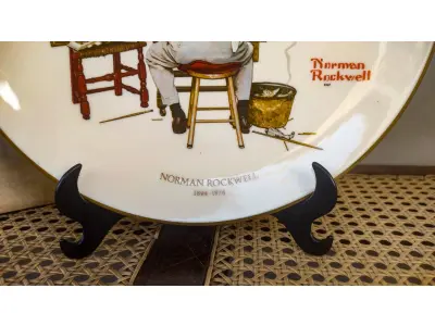 LOTE 076 - 01 RARO PRATO DE PAREDE GRANDE DE MEADOS DO SÉCULO PARA AMANTES E COLECIONADORES DE NORMAN ROCKWELL! ESTE É UM PRATO COLECIONÁVEL DE PORCELANA VINTAGE DE EDIÇÃO LIMITADA. FEITO POR GORHAM EM 1978, ESTE BELO PRATO  MOSTRA UMA CÓPIA DO "TRIPLE SELF PORTRAIT" DE NORMAN ROCKWELL, QUE FOI PUBLICADO ORIGINALMENTE NA CAPA DO SATURDAY EVENING POST UM EVENTO DE 13 DE FEVEREIRO DE 1960 NOS EUA . A CENA MOSTRA UM ARTISTA OLHANDO SEU REFLEXO NO ESPELHO E USÁ-LO PARA ESBOÇAR SEU AUTORRETRATO. É O PRESENTE DE DECORAÇÃO AMERICANA PERFEITO, CONDIÇÃO EXCELENTE! ESTA PLACA FOI ENCONTRADA EM UM ARMÁRIO DURANTE A VENDA DE UMA PROPRIEDADE, APÓS MUITOS ANOS GUARDADA.  CAIXA ORIGINAL. O PRATO MEDE 26,5 CM DE DIÂMETRO.  SUPORTE PARA PRATO NÃO INCLUÍDO NESTA VENDA. (NO ESTADO) ATENÇÃO! FAZER A VISITAÇÃO ANTES DE ARREMATAR, NÃO SABEMOS SE FUNCIONA, LEILÃO NÃO TEM GARANTIA E NEM DEVOLUÇÃO, SUJEITO A POSSÍVEIS AVARIAS VISÍVEIS/OCULTAS E/OU AUSÊNCIA DE COMPONENTES.