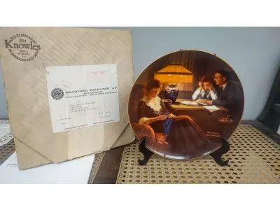 LOTE 090 - 01 RARO PRATO DE NORMAN ROCKWELL COM21 CM DE DIÂMETRO. A PRIMEIRA EDIÇÃO LIMITADA "FATHER'S HELP" DE CERTIFICADO COMO UM "VERDADEIRO CLÁSSICO ROCKWELL" PELA ROCKWELL SOCIETY OF AMERICA.FEITO EM UMA EDIÇÃO ESTRITAMENTE LIMITADA A 150 DIAS DE QUEIMA NOS EUA. POR KNOWLES, O NOME MAIS ANTIGO DA AMÉRICA EM FINE PORCELANA CHINA. ITEM DE COLECIONADOR DA SÉRIE LIGHT CAMPAIGN DE NORMAN ROCKWELL. ESTE PRATO VINTAGE DO FINAL DO SÉCULO XX (1980-1989) APRESENTA O CLÁSSICO DESIGN "AJUDA DO PAI" E FOI FABRICADO NOS ESTADOS UNIDOS. ITEM FOI ENCONTRADO EM UM ARMÁRIO DURANTE A VENDA DE UMA PROPRIEDADE NOS EUA APÓS MUITOS ANOS GUARDADOS.  CAIXA “ORIGINAL E COM CERTIFICADO DE AUTENTICIDADE, SUPORTE PARA PRATO NÃO INCLUÍDO NESTA VENDA. (NO ESTADO) ATENÇÃO! FAZER A VISITAÇÃO ANTES DE ARREMATAR, NÃO SABEMOS SE FUNCIONA, LEILÃO NÃO TEM GARANTIA E NEM DEVOLUÇÃO, SUJEITO A POSSÍVEIS AVARIAS VISÍVEIS/OCULTAS E/OU AUSÊNCIA DE COMPONENTES.