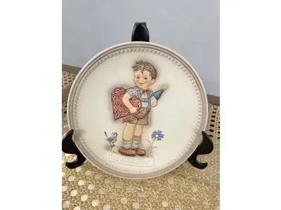 01 RARO PRATO DE PORCELANA LINDAMENTE TRABALHADO DA FAMOSA M.J. HUMMEL GOEBEL APRESENTA UM FORMATO REDONDO E DESIGN MULTICOLORIDO, PERFEITO PARA TODAS AS OCASIÕES E ESTILOS DE DECORAÇÃO. É UM ITEM DE COLECIONADOR DA SEGUNDA EDIÇÃO DO PRATO VALENTINE JOY, GRAVADO COM DETALHES INTRINCADOS E FABRICADO NA ALEMANHA NA DÉCADA DE 1980.PEÇA ÚNICA DA CULTURA ALEMÃ E VEM DA FRANQUIA GOEBEL, UMA MARCA RENOMADA NO SETOR DE COLECIONÁVEIS ​​DECORATIVOS. LANÇADA SOMENTE PARA MEMBROS DO CLUBE DE COLECIONADORES GOEBEL. ITEM COMPRADO EM GARAGENS DE ANTIGUIDADES NOS EUA.SUPORTE PARA PRATO NÃO INCLUÍDO NESTA VENDA. (NO ESTADO) ATENÇÃO! FAZER A VISITAÇÃO ANTES DE ARREMATAR, NÃO SABEMOS SE FUNCIONA, LEILÃO NÃO TEM GARANTIA E NEM DEVOLUÇÃO, SUJEITO A POSSÍVEIS AVARIAS VISÍVEIS/OCULTAS E/OU AUSÊNCIA DE COMPONENTES.