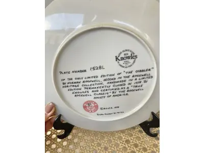 LOTE 082 - 01 RARO PRATO DE NORMAN ROCKWELL  PEÇA DE COLECIONADOR VINTAGE 8-1/2" THE COBBLER 2ND HERITAGE DE KNOWLES 1978 EDWIN M. KNOWLES. EDIÇÃO LIMITADA DE NORMAN ROCKWELL, "VERDADEIRO CLÁSSICO ROCKWELL"" PELA ROCKWELL SOCIETY OF AMERICA CAIXA ORIGINAL. O PRATO MEDE 21,5 CM DE DIÂMETRO. ITEM. FOI ENCONTRADA EM UM ARMÁRIO DURANTE A VENDA DE UMA PROPRIEDADE, APÓS MUITOS ANOS GUARDADOS.  CAIXA ORIGINAL. “SUPORTE PARA PRATO NÃO INCLUÍDO NESTA VENDA. (NO ESTADO) ATENÇÃO! FAZER A VISITAÇÃO ANTES DE ARREMATAR, NÃO SABEMOS SE FUNCIONA, LEILÃO NÃO TEM GARANTIA E NEM DEVOLUÇÃO, SUJEITO A POSSÍVEIS AVARIAS VISÍVEIS/OCULTAS E/OU AUSÊNCIA DE COMPONENTES.