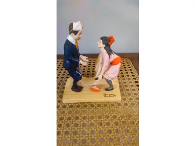 LOTE 207 - 01 ESTATUETA VINTAGE DE NORMAN ROCKWELL FEITA NO JAPÃO, BELA ESTATUETA DE PORCELANA RETRATA UMA MENINA E UM MENINO EM SUA PRIMEIRA DANÇA. CRIADA PELO RENOMADO ARTISTA NORMAN ROCKWELL, ESTA PEÇA É UMA REPRODUÇÃO LICENCIADA DO FINAL DO SÉCULO XX. MEDINDO 12 CM DE COMPRIMENTO E MENOS DE 16 CM DE ALTURA, É UMA ESTATUETA DE TAMANHO MÉDIO QUE SERIA UMA ÓTIMA ADIÇÃO A QUALQUER AMBIENTE. A ESTATUETA É FEITA À MÃO COM ACABAMENTO EM PINTURA E APRESENTA DETALHES MULTICOLORIDOS. É UMA PEÇA DE ESTILO MODERNO QUE APRESENTA FIGURAS HISTÓRICAS E É PERFEITA PARA COLECIONADORES, FOI PRODUZIDA NO JAPÃO COM TÉCNICAS DE PRODUÇÃO PROFISSIONAL.COMPRADAS EM LOJAS DE ANTIGUIDADES DOS EUA. OBS PEÇA COM RESTAURO. (NO ESTADO) ATENÇÃO! FAZER A VISITAÇÃO ANTES DE ARREMATAR, NÃO SABEMOS SE FUNCIONA, LEILÃO NÃO TEM GARANTIA E NEM DEVOLUÇÃO, SUJEITO A POSSÍVEIS AVARIAS VISÍVEIS/OCULTAS E/OU AUSÊNCIA DE COMPONENTES.