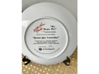 LOTE 042 - 01 RARO PRATO DE PAREDE DE PORCELANA MY MAGIC HAT DA SÉRIE RUSTY MONEY PARECE QUE FOI ONTEM, SÉRIE "SEEMS LIKE YESTERDAY" "MY QUINTA EDIÇÃO PRODUÇÃO LIMITADA POR APENAS 10 DIAS DE PRODUÇÃO ,ENCERRADA DEFINITIVAMENTE, COM 21 CM DE DIAMETRÔ COM CERTIFICAFO DE AUNTECIDADE ITEM COMPRADO EM GARAGENS DE ANTIGUIDADES NOS EUA.SUPORTE PARA PRATO NÃO INCLUÍDO NESTA VENDA. (NO ESTADO) ATENÇÃO! FAZER A VISITAÇÃO ANTES DE ARREMATAR, NÃO SABEMOS SE FUNCIONA, LEILÃO NÃO TEM GARANTIA E NEM DEVOLUÇÃO, SUJEITO A POSSÍVEIS AVARIAS VISÍVEIS/OCULTAS E/OU AUSÊNCIA DE COMPONENTES.