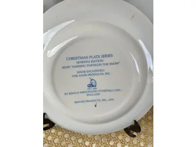 LOTE 040 - 01 LINDO PRATO DE NATAL DA SÉRIE AVON CHRISTMAS PLATE  PRATO DE COLECIONADOR FEITO NA INGLATERRA POR ENOCH WEDGWOOD (TUNSTALL) EM 1979.COM 21,5 CM DE DIÂMETRO A IMPRESSÃO NESTE PRATO É DE "DASHING THROUGH THE SNOW" COM DOIS ANÉIS DE OURO 22K E O NATAL DE 1979 TAMBÉM EM OURO 22K. ITEM COMPRADO EM GARAGENS DE ANTIGUIDADES NOS EUA.SUPORTE PARA PRATO NÃO INCLUÍDO NESTA VENDA. (NO ESTADO) ATENÇÃO! FAZER A VISITAÇÃO ANTES DE ARREMATAR, NÃO SABEMOS SE FUNCIONA, LEILÃO NÃO TEM GARANTIA E NEM DEVOLUÇÃO, SUJEITO A POSSÍVEIS AVARIAS VISÍVEIS/OCULTAS E/OU AUSÊNCIA DE COMPONENTES.