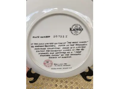 LOTE 210 - 01 RARO PRATO VINTAGE DE COLECIONADOR APRESENTA A ICÔNICA PINTURA DE NORMAN ROCKWELL, "THE MUSIC MAKER". COM 21 CM DE DIÂMETRO, E É FEITO DE PORCELANA. O PRATO FAZ PARTE DA FRANQUIA "KNOWLES" DE EDIÇÃO LIMITADA E PERTENCE À LINHA DE PRODUTOS "EARLY AMERICAN PRESCUT/EAPC".O PRATO É DECORADO COM UM PADRÃO RÚSTICO E APRESENTA UMA IMAGEM COLORIDA DE UM HOMEM TOCANDO UM INSTRUMENTO MUSICAL. FOI PRODUZIDO COM A TÉCNICA DE CERÂMICA E FABRICADO NOS ESTADOS UNIDOS NO FINAL DO SÉCULO XX (1970-1999). ESTE PRATO DECORATIVO É PERFEITO PARA TODAS AS OCASIÕES E SERIA UM ÓTIMO COMPLEMENTO PARA QUALQUER COLEÇÃO. NÚMERO DA PLACA: 20755I.COMPRADAS EM LOJAS DE ANTIGUIDADES DOS EUA.O SUPORTE DO PRATO NÃO ESTÁ INCLUÍDO.