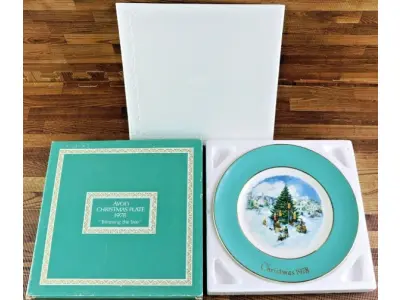 LOTE 106 - 01 LINDO PRATO DE NATAL DA SÉRIE AVON CHRISTMAS PLATE DE 1978, "APARANDO A ÁRVORE" - SEXTA EDIÇÃO DA SÉRIE. COM 22 CM DE DIÂMETRO E RETRATA UM GRUPO DE CRIANÇAS EM EPOCA DE NATAL MONTADO ARVORE DE NATAL. O VERSO MARCADO: SÉRIE DE PRATOS DE NATAL SEXTA EDIÇÃO "APARANDO A ÁRVORE" COM DOIS ANÉIS DE OURO 22K E O NATAL DE 1979 TAMBÉM EM OURO 22K.FEITO EXCLUSIVAMENTE PARA A AVON CTS INC., 1978 POR ENOCH WEDGWOOD (TUNSTALL) LTD,INGLATERRA PEÇA COMPRADA EM GARAGEM DE ANTIGUIDADES NOS EUA. SUPORTE PARA PRATO NÃO INCLUÍDO NESTA VENDA. (NO ESTADO) ATENÇÃO! FAZER A VISITAÇÃO ANTES DE ARREMATAR, NÃO SABEMOS SE FUNCIONA, LEILÃO NÃO TEM GARANTIA E NEM DEVOLUÇÃO, SUJEITO A POSSÍVEIS AVARIAS VISÍVEIS/OCULTAS E/OU AUSÊNCIA DE COMPONENTES.