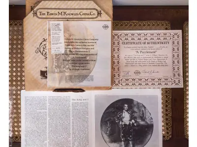 LOTE 017 - 01 ADORADO PRATO DE COLECIONADOR INTITULADO "UM ENIGMA" É UM PRATO DE COLECIONADOR DE EDIÇÃO LIMITADA DA SÉRIE  "THE KING AND" "EM PORTUGUES O REI E EU", DE KNOWLES.PINTADO À MÃO POR WILLIAM CHAMBERS. VENDIDO APENAS POR 150 DIAS E LOGO FOI ENCERRADA AS VENDAS NOS EUA.COM NOTA DE COMPRA DATADA EM 27/07/1984 EM 1980.O PRATO MEDE APROXIMADAMENTE 21 CM E ESTÁ EM EXCELENTE ESTADO.NÚMERO DO PRATO: 19725G.COM CAIXA E CERTIFICADO, MANTIDO EM CASA LIVRE DE FUMO.PEÇA COMPRADA EM GARAGEM DE ANTIGUIDADES NOS EUA. “SUPORTE PARA PRATO NÃO INCLUÍDO NESTA VENDA.”ITEM COMPRADO EM GARAGENS DE ANTIGUIDADES NOS EUA. (NO ESTADO) ATENÇÃO! FAZER A VISITAÇÃO ANTES DE ARREMATAR, NÃO SABEMOS SE FUNCIONA, LEILÃO NÃO TEM GARANTIA E NEM DEVOLUÇÃO, SUJEITO A POSSÍVEIS AVARIAS VISÍVEIS/OCULTAS E/OU AUSÊNCIA DE COMPONENTES.