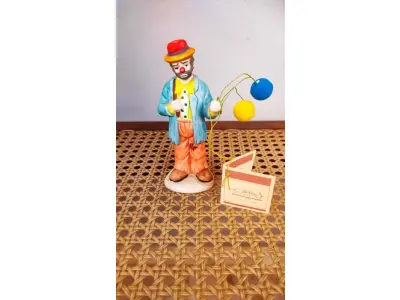 LOTE 198 - 01 ESTATUETA RARA DE SE ACHAR NOS EUA DE PALHAÇO DE CERÂMICA VINTAGE DA COLEÇÃO FLAMBRO DE EMMETT KELLY JR. PAÍS/REGIÃO DE FABRICAÇÃO TAIWAN. ESTA ESTATUETA DO EMMETT KELLY JR. APRESENTA UM PALHAÇO EMMETT KELLY JR. PALHAÇO CARENTE  COM BALÕES ORIGINAL. EXCELENTE ESTADO, SEM LASCAS, RACHADURAS EM ÓTIMO ESTADO PEÇA RARA ITEM LANÇADOS ANOS 90 NOS EUA  CM DE ALTURA E UMA BASE DE 15 ​​CM. COM  SUA ASSINATURA NA PARTE INFERIOR JUNTO COM "EXCLUSIVAMENTE DA FLAMBRO EMPRESA FAMOSA NOS EUA DECADA DE 90, COMPRADAS EM LOJAS DE ANTIGUIDADES DOS EUA. (NO ESTADO) ATENÇÃO! FAZER A VISITAÇÃO ANTES DE ARREMATAR, NÃO SABEMOS SE FUNCIONA, LEILÃO NÃO TEM GARANTIA E NEM DEVOLUÇÃO, SUJEITO A POSSÍVEIS AVARIAS VISÍVEIS/OCULTAS E/OU AUSÊNCIA DE COMPONENTES.