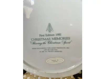 LOTE 058 - 01 PRATO DE NATAL COLECIONÁVEL DA AVON CHRISTMAS MEMORIAS DE 1981, O PRIMEIRO DA SÉRIE. COMPRANDO EM LOJA DE ANTIGUIDADES NO JAPÃO. COM ACABAMENTO EM OURO 22K, APRESENTA UMA MARAVILHOSA CENA VINTAGE DE UM MENINO E UMA MENINA LEVANDO A ÁRVORE E AS PLANTAS PARA CASA PARA AS FESTAS DE FIM DE ANO. CORES E DETALHES LINDOS. EM ÓTIMO ESTADO, COM LEVE DESGASTE NA BORDA INFERIOR DO PRATO E LEVES ARRANHÕES. COM CAIXA. TEM 23 CM DE DIÂMETRO.SUPORTE PARA PRATO NÃO INCLUÍDO NESTA VENDA. (NO ESTADO) ATENÇÃO! FAZER A VISITAÇÃO ANTES DE ARREMATAR, NÃO SABEMOS SE FUNCIONA, LEILÃO NÃO TEM GARANTIA E NEM DEVOLUÇÃO, SUJEITO A POSSÍVEIS AVARIAS VISÍVEIS/OCULTAS E/OU AUSÊNCIA DE COMPONENTES.