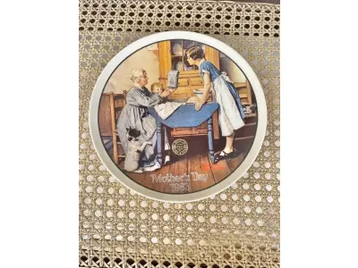 LOTE 050 - 01 RARO PRATO DE "1983 ADD TWO CUPS AND A MEASURE OF LOVE - COLLECTIBLE PORCELAIN PLATE", DE NORMAN ROCKWELL! FABRICADO PELA KNOWLES, A MARCA MAIS ANTIGA DA AMÉRICA EM PORCELANA FINA. MEDE APROXIMADAMENTE 21,5 CM DE DIÂMETRO.NO VERSO DO PRATO ESTÁ ESCRITO: "DA PRIMEIRA EDIÇÃO LIMITADA, 'ADD TWO CUPS AND A MEASURE OF LOVE', DE NORMAN ROCKWELL. O OITAVO DE UMA SÉRIE ANUAL PARA O DIA DAS MÃES. COM CERTIFICADO DE ALTENCIDADE PELA ROCKWELL SOCIETY OF AMERICA. FEITO EM EDIÇÃO LIMITADA, PERMANENTEMENTE FECHADO EM 8 DE MAIO DE 1983, POR KNOWLES.ITEM COMPRADO EM GAREGEM DE ANTIGUIDADES NOS EUA.SUPORTE PARA PRATO NÃO INCLUÍDO NESTA VENDA. (NO ESTADO) ATENÇÃO! FAZER A VISITAÇÃO ANTES DE ARREMATAR, NÃO SABEMOS SE FUNCIONA, LEILÃO NÃO TEM GARANTIA E NEM DEVOLUÇÃO, SUJEITO A POSSÍVEIS AVARIAS VISÍVEIS/OCULTAS E/OU AUSÊNCIA DE COMPONENTES.