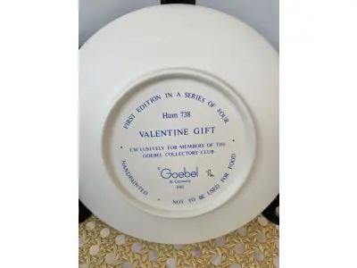 LOTE 060 - 01 RARO PRATO DE PORCELANA LINDAMENTE TRABALHADO DA FAMOSA M.J. HUMMEL GOEBEL APRESENTA UM FORMATO REDONDO E DESIGN MULTICOLORIDO, PERFEITO PARA TODAS AS OCASIÕES E ESTILOS DE DECORAÇÃO. É UM ITEM DE COLECIONADOR DA PRIMEIRA  EDIÇÃO DO PRATO VALENTINE GIFT, GRAVADO COM DETALHES INTRINCADOS E FABRICADO NA ALEMANHA NA DÉCADA DE 1980.PEÇA ÚNICA DA CULTURA ALEMÃ E VEM DA FRANQUIA GOEBEL, UMA MARCA RENOMADA NO SETOR DE COLECIONÁVEIS DECORATIVOS. LANÇADA SOMENTE PARA MEMBROS DO CLUBE DE COLECIONADORES GOEBEL. ITEM COMPRADO EM GARAGENS DE ANTIGUIDADES NOS EUA. OS ORIGINAIS OS PREÇO EM OUTROS PAÍSES  E DE 200 A 500 DÓLARES POR PEÇA VEJA NA FOTO .SUPORTE PARA PRATO NÃO INCLUÍDO NESTA VENDA. (NO ESTADO) ATENÇÃO! FAZER A VISITAÇÃO ANTES DE ARREMATAR, NÃO SABEMOS SE FUNCIONA, LEILÃO NÃO TEM GARANTIA E NEM DEVOLUÇÃO, SUJEITO A POSSÍVEIS AVARIAS VISÍVEIS/OCULTAS E/OU AUSÊNCIA DE COMPONENTES.