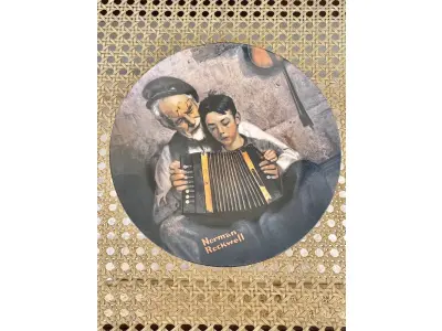 LOTE 210 - 01 RARO PRATO VINTAGE DE COLECIONADOR APRESENTA A ICÔNICA PINTURA DE NORMAN ROCKWELL, "THE MUSIC MAKER". COM 21 CM DE DIÂMETRO, E É FEITO DE PORCELANA. O PRATO FAZ PARTE DA FRANQUIA "KNOWLES" DE EDIÇÃO LIMITADA E PERTENCE À LINHA DE PRODUTOS "EARLY AMERICAN PRESCUT/EAPC".O PRATO É DECORADO COM UM PADRÃO RÚSTICO E APRESENTA UMA IMAGEM COLORIDA DE UM HOMEM TOCANDO UM INSTRUMENTO MUSICAL. FOI PRODUZIDO COM A TÉCNICA DE CERÂMICA E FABRICADO NOS ESTADOS UNIDOS NO FINAL DO SÉCULO XX (1970-1999). ESTE PRATO DECORATIVO É PERFEITO PARA TODAS AS OCASIÕES E SERIA UM ÓTIMO COMPLEMENTO PARA QUALQUER COLEÇÃO. NÚMERO DA PLACA: 20755I.COMPRADAS EM LOJAS DE ANTIGUIDADES DOS EUA.O SUPORTE DO PRATO NÃO ESTÁ INCLUÍDO.