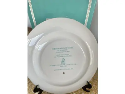 LOTE 106 - 01 LINDO PRATO DE NATAL DA SÉRIE AVON CHRISTMAS PLATE DE 1978, "APARANDO A ÁRVORE" - SEXTA EDIÇÃO DA SÉRIE. COM 22 CM DE DIÂMETRO E RETRATA UM GRUPO DE CRIANÇAS EM EPOCA DE NATAL MONTADO ARVORE DE NATAL. O VERSO MARCADO: SÉRIE DE PRATOS DE NATAL SEXTA EDIÇÃO "APARANDO A ÁRVORE" COM DOIS ANÉIS DE OURO 22K E O NATAL DE 1979 TAMBÉM EM OURO 22K.FEITO EXCLUSIVAMENTE PARA A AVON CTS INC., 1978 POR ENOCH WEDGWOOD (TUNSTALL) LTD,INGLATERRA PEÇA COMPRADA EM GARAGEM DE ANTIGUIDADES NOS EUA. SUPORTE PARA PRATO NÃO INCLUÍDO NESTA VENDA. (NO ESTADO) ATENÇÃO! FAZER A VISITAÇÃO ANTES DE ARREMATAR, NÃO SABEMOS SE FUNCIONA, LEILÃO NÃO TEM GARANTIA E NEM DEVOLUÇÃO, SUJEITO A POSSÍVEIS AVARIAS VISÍVEIS/OCULTAS E/OU AUSÊNCIA DE COMPONENTES.