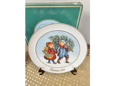 LOTE 058 - 01 PRATO DE NATAL COLECIONÁVEL DA AVON CHRISTMAS MEMORIAS DE 1981, O PRIMEIRO DA SÉRIE. COMPRANDO EM LOJA DE ANTIGUIDADES NO JAPÃO. COM ACABAMENTO EM OURO 22K, APRESENTA UMA MARAVILHOSA CENA VINTAGE DE UM MENINO E UMA MENINA LEVANDO A ÁRVORE E AS PLANTAS PARA CASA PARA AS FESTAS DE FIM DE ANO. CORES E DETALHES LINDOS. EM ÓTIMO ESTADO, COM LEVE DESGASTE NA BORDA INFERIOR DO PRATO E LEVES ARRANHÕES. COM CAIXA. TEM 23 CM DE DIÂMETRO.SUPORTE PARA PRATO NÃO INCLUÍDO NESTA VENDA. (NO ESTADO) ATENÇÃO! FAZER A VISITAÇÃO ANTES DE ARREMATAR, NÃO SABEMOS SE FUNCIONA, LEILÃO NÃO TEM GARANTIA E NEM DEVOLUÇÃO, SUJEITO A POSSÍVEIS AVARIAS VISÍVEIS/OCULTAS E/OU AUSÊNCIA DE COMPONENTES.