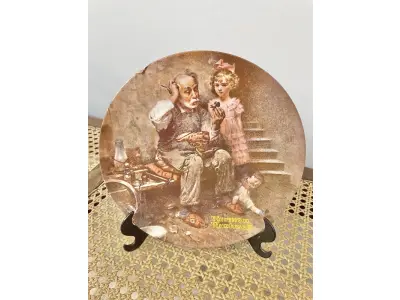 LOTE 100 - 01 RARO PRATO EDIÇÃO LIMITADA AUTÊNTICA DE "THE COBBLER" DE NORMAN ROCKWELL, COM CERTIFICADO DE AUTENTICIDADE  PRATO COLECIONÁVEL COM 21 CM DE DIÂMETRO . SEGUNDO NA COLEÇÃO DE HERANÇA ROCKWELL. FEITO À MÃO EM UMA EDIÇÃO LIMITADA, FOI FECHADO PERMANENTEMENTE EM 1978 POR KNOWLES E CERTIFICADO COMO UM "TRUE ROCKWELL CLASSIC" PELA ROCKWELL SOCIETY OF AMERICA. NORMAN ROCKWELL AUTENTICADO ARTESANATO DA EDWIN M. KNOWLES CHINA CO. DE 1854.PEÇA COMPRADA EM GARAGEM DE ANTIGUIDADES NOS EUA. SUPORTE PARA PRATO NÃO INCLUÍDO NESTA VENDA. (NO ESTADO) ATENÇÃO! FAZER A VISITAÇÃO ANTES DE ARREMATAR, NÃO SABEMOS SE FUNCIONA, LEILÃO NÃO TEM GARANTIA E NEM DEVOLUÇÃO, SUJEITO A POSSÍVEIS AVARIAS VISÍVEIS/OCULTAS E/OU AUSÊNCIA DE COMPONENTES.