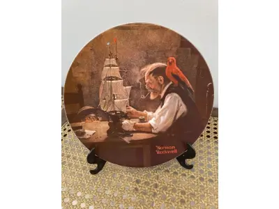 01 PRATO DE COLECIONADOR  "O CONSTRUTOR DE NAVIOS "THE SHIP BUILDER " DA ROYAL EATON NORMAN ROCKWELL, PRATO NUMERADO 11387 A PRATO NORMAN ROCKWELL DE 1980 "O CONSTRUTOR DE NAVIOS. EDIÇÃO LIMITADA  COM 21,5 CM DE DIÂMETRO, MULTICOLORIDO, COM DETALHES EM OURO 22 QUILATES. REPRESENTA UM VELHO E UM MENINO COM SEU CACHORRO OLHANDO PARA O MAR. SUPORTE DO PRATO NÃO ESTÁ INCLUÍDO. ITEM COMPRADO EM GARAGENS DE ANTIGUIDADES NOS EUA. (NO ESTADO) ATENÇÃO! FAZER A VISITAÇÃO ANTES DE ARREMATAR, NÃO SABEMOS SE FUNCIONA, LEILÃO NÃO TEM GARANTIA E NEM DEVOLUÇÃO, SUJEITO A POSSÍVEIS AVARIAS VISÍVEIS/OCULTAS E/OU AUSÊNCIA DE COMPONENTES.