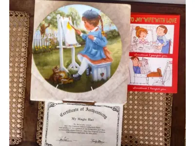 LOTE 325 - 01 PRATO DE COLECIONADOR SÉRIE PARECE QUE FOI ONTEM "SEEMS LIKE YESTERDAY" "EM PORTUGUES PARECE QUE FOI ONTEM" "MY MAGIC HAT" MEU CHAPÉU MÁGICO" PRODUZIDA EM EDIÇÃO LIMITADA POR APENAS 10 DIAS DE DISTRIBUIÇÃO E LOGO FECHADO PARA SEMPRE. PRATO DE NUMERO 6537 .PLACA DE COLECIONADOR B0Y RUSTY MONEY ESSA PEÇA FOI AUTOGRAFADA À MÃO PELO ARTISTA NA EPOCA DE LANÇAMENTO DOS PRATOS NOS EUA EM 30/03/1983. APRESENTA UMA CENA IT"" DA RUSTY MONEY, 3ª EDIÇÃO. E FOI FABRICADO ENTRE 1980 E 1989. É PERFEITO PARA COLECIONADORES DE ITENS DECORATIVOS AMERICANOS, ESPECIALMENTE PARA AQUELES INTERESSADOS EM PRATOS DE COLECIONADOR. EMITIDO PELA RJ ERNST ENTERPRISES. ACOMPANHA O CERTIFICADO DE AUTENTICIDADE NA CAIXA ORIGINAL. COM 22 CM DE DIÂMETRO. PEÇA COMPRADA EM GARAGEM DE ANTIGUIDADES NOS EUA. “SUPORTE PARA PRATO NÃO INCLUÍDO NESTA VENDA.” . (NO ESTADO) ATENÇÃO! FAZER A VISITAÇÃO ANTES DE ARREMATAR, NÃO SABEMOS SE FUNCIONA, LEILÃO NÃO TEM GARANTIA E NEM DEVOLUÇÃO, SUJEITO A POSSÍVEIS AVARIAS VISÍVEIS/OCULTAS E/OU AUSÊNCIA DE COMPONENTES.