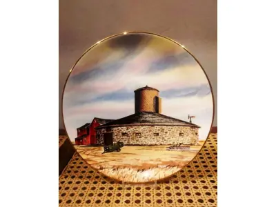 LOTE 316 - 01 RARO PRATO PORCELANA DA COLEÇÃO CELEIROS AMERICANOS EM EXTINÇÃO FRANCISCANA DA HISTORIC PROVIDENCE MINT WORLD PREMIER FIRST EDITION, DE 1983, DA SÉRIE THE VANISHING AMERICAN BARN, DA HARRIS HIEN, A SEGUNDA EDIÇÃO DA SÉRIE, INTITULADA "ROUND  BARN". EM PORTUGUES “CELEIRO REDONDO” O PRATO APRESENTA UMA REPRESENTAÇÃO ÚNICA, DETALHADA E COLORIDA DE UM TIPO DE CELEIRO AMERICANO, SITUADO EM UM CENÁRIO DE FAZENDA DE DIFERENTES REGIÕES DO PAÍS, COM DETALHES DOURADOS NA BORDA. ESTAMPADAS NA PARTE INFERIOR COM O NOME DA SÉRIE, TÍTULO, ASSINATURA IMPRESSA DO ARTISTA E A MARCA THE HISTORIC PROVIDENCE MINT, E MEDEM APROXIMADAMENTE 21,8 CM DE DIÂMETRO. EM EXCELENTE ESTADO, POSSUI A CAIXA ORIGINAL E OS DOCUMENTOS. O SUPORTE DO PRATO NÃO ESTÁ INCLUÍDO. PEÇA COMPRADA EM GARAGEM DE ANTIGUIDADES NOS EUA. SUPORTE PARA PRATO NÃO INCLUÍDO NESTA VENDA. (NO ESTADO) ATENÇÃO! FAZER A VISITAÇÃO ANTES DE ARREMATAR, NÃO SABEMOS SE FUNCIONA, LEILÃO NÃO TEM GARANTIA E NEM DEVOLUÇÃO, SUJEITO A POSSÍVEIS AVARIAS VISÍVEIS/OCULTAS E/OU AUSÊNCIA DE COMPONENTES.