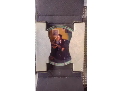 LOTE 185 - 01 PRATO SONHO DE UM JOVEM, QUINTO NA SÉRIE ROCKWELL AMERICAN DREAM, PRATO DE EXPOSIÇÃO VINTAGE, 1986,PLACA DA EDWIN KNOWLES CHINA COMPANY, NÚMERO 14027B  GUARDADO A ANOS.CAIXA ORIGINAL + CERTIFICADO DE AUTORIZAÇÃO + BROCHURA INFORMATIVA PARA ESTA PLACA DE COLECIONADOR DA SÉRIE DE PLACAS DA COLEÇÃO ROCKWELL'S AMERICAN DREAM (BRADFORD EXCHANGE) DO ARTISTA NORMAN ROCKWELL. THE EDWARD M. KNOWLES CHINA COMPANY. ROCKWELL SOCIETY OF AMERICA. AS EDIÇÕES FORAM LIMITADAS A UM MÁXIMO DE 150 DIAS DE QUEIMA. A PLACA ESTÁ EM PERFEITAS CONDIÇÕES, SEM USO E SEM EXPOSIÇÃO. COM  21 CM DE DIÂMETRO. 1986. BRADEX Nº 84-R70-7.5 ARTISTA: NORMAN ROCKWELL. ITEM COMPRADO EM GARAGENS DOS EUA. COM CERTIFICADO DE AUTENTICIDADE E SELO DE ORIGINALIDADE NO PRATO.O SUPORTE DO PRATO NÃO ESTÁ INCLUÍDO. (NO ESTADO) ATENÇÃO! FAZER A VISITAÇÃO ANTES DE ARREMATAR, NÃO SABEMOS SE FUNCIONA, LEILÃO NÃO TEM GARANTIA E NEM DEVOLUÇÃO, SUJEITO A POSSÍVEIS AVARIAS VISÍVEIS/OCULTAS E/OU AUSÊNCIA DE COMPONENTES.