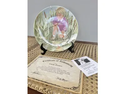 LOTE 122 - 01 PRATO DECORATIVO 'PEQUENO PRÍNCIPE' - POR RUSTY MONEY - SEXTA EDIÇÃO DA SÉRIE "PARECE ONTEM" - PRODUZIDO EM EDIÇÃO LIMITADA POR APENAS DEZ DIAS DE QUEIMA E DEPOIS FECHADO PERMANENTEMENTE - NÚMERO DA PLACA 4874, COM CAIXA ORIGINAL E CERTIFICADO DE AUTENTICIDADE. MEDE 21,5 CM DE DIÂMETRO SUPORTE PARA PRATO NÃO INCLUÍDO NESTA VENDA. (NO ESTADO) ATENÇÃO! FAZER A VISITAÇÃO ANTES DE ARREMATAR, NÃO SABEMOS SE FUNCIONA, LEILÃO NÃO TEM GARANTIA E NEM DEVOLUÇÃO, SUJEITO A POSSÍVEIS AVARIAS VISÍVEIS/OCULTAS E/OU AUSÊNCIA DE COMPONENTES.