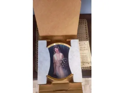 LOTE 326 - 01  PRATO "MOMENTOS ESPECIAIS" DE BESSIE PEASE GUTMANN. PRATO DE COLECIONADOR DE EDIÇÃO LIMITADA.PORCELANA FINA COM ACABAMENTO EM OURO 23 QUILATES. ACOMPANHA CERTIFICADO DE AUTENTICIDADE E CAIXA. ESTE É UM BELO PRATO INTITULADO "ON THE THRESHOLD", " EM PORTUGUES O LIMIAR"DE BESSIE PEASE GUTMANN. FOI FEITO PELA WOODMERE CHINA EM NEW CASTLE, PENSILVÂNIA. ESTÁ EM PERFEITAS CONDIÇÕES, SEM LASCAS, RACHADURAS OU ARRANHÕES. ESTE É UM PRATO DE EDIÇÃO LIMITADA, NUMERADO 1078 PRATO MEDE 23,2 CM DE DIÂMETRO.PEÇA COMPRADA EM GARAGEM DE ANTIGUIDADES NOS EUA. “SUPORTE PARA PRATO NÃO INCLUÍDO NESTA VENDA.” . (NO ESTADO) ATENÇÃO! FAZER A VISITAÇÃO ANTES DE ARREMATAR, NÃO SABEMOS SE FUNCIONA, LEILÃO NÃO TEM GARANTIA E NEM DEVOLUÇÃO, SUJEITO A POSSÍVEIS AVARIAS VISÍVEIS/OCULTAS E/OU AUSÊNCIA DE COMPONENTES.