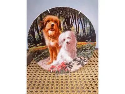 LOTE 328 - 01 PRATO BENJI E TIFFANY É O NÚMERO 2 DE UMA SÉRIE DE PRATOS INTITULADA "WAGS TO RICHES" DA CREATIVE WORLD. COM 21,8 CM DE DIÂMETRO E É LIMITADO A 19.500 PRATOS DO ARTISTA MURRAY KARN, ESTE E O PRATO DE NUMERO 844,1982. E PRODUZIDO PELA ROYAL MANOR PORCELAIN, É A 2ª EDIÇÃO DA COLEÇÃO WAGS TO RICHES.O PRATO ESTÁ EM EXCELENTE ESTADO. COM CERTIFICADO E CAIXA.PEÇA COMPRADA EM GARAGEM DE ANTIGUIDADES NOS EUA. “SUPORTE PARA PRATO NÃO INCLUÍDO NESTA VENDA.”