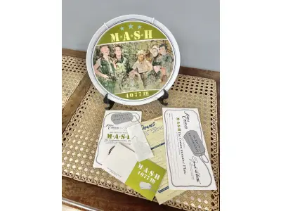 LOTE 120 - 01 LINDO PRATO DE COLECIONADOR MASH 4077ª EDIÇÃO ÚLTIMA TEMPORADA DA SÉRIE DE TELEVISÃO MASH, LIMITADA NA CAIXA ORIGINAL. COM  21,5 CM DE DIÂMETRO, FABRICADO EM 1982 PELA ROYAL ORLEANS PARA A TWENTIETH CENTURY-FOX. UM PRATO MUITO BONITO. NO VERSO, HÁ UMA LISTA COM O NOME DOS ATORES. DISTRIBUÍDO EXCLUSIVAMENTE PELA ROYAL ORLEANS, NOVA ORLEANS, LA. COM CERTIFICADO DE AUTENTICIDADE E DOCUMENTOS. ITEM COMPRADO E GARAGENS DE ANTIGUIDADES NOS EUA. SUPORTE PARA PRATO NÃO INCLUÍDO NESTA VENDA. (NO ESTADO) ATENÇÃO! FAZER A VISITAÇÃO ANTES DE ARREMATAR, NÃO SABEMOS SE FUNCIONA, LEILÃO NÃO TEM GARANTIA E NEM DEVOLUÇÃO, SUJEITO A POSSÍVEIS AVARIAS VISÍVEIS/OCULTAS E/OU AUSÊNCIA DE COMPONENTES.