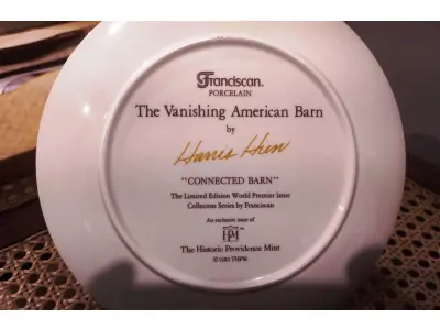 01 RARO PRATO PORCELANA DA COLEÇÃO CELEIROS AMERICANOS EM EXTINÇÃO FRANCISCANA DA HISTORIC PROVIDENCE MINT WORLD PREMIER FIRST EDITION, DE 1983, DA SÉRIE THE VANISHING AMERICAN BARN, DA HARRIS HIEN, A SEGUNDA EDIÇÃO DA SÉRIE, INTITULADA "CONNECTED BARN". EM PORTUGUES “CELEIRO CONECTADO” O PRATO APRESENTA UMA REPRESENTAÇÃO ÚNICA, DETALHADA E COLORIDA DE UM TIPO DE CELEIRO AMERICANO, SITUADO EM UM CENÁRIO DE FAZENDA DE DIFERENTES REGIÕES DO PAÍS, COM DETALHES DOURADOS NA BORDA. ESTAMPADAS NA PARTE INFERIOR COM O NOME DA SÉRIE, TÍTULO, ASSINATURA IMPRESSA DO ARTISTA E A MARCA THE HISTORIC PROVIDENCE MINT, E MEDEM APROXIMADAMENTE 21,8 CM DE DIÂMETRO. EM EXCELENTE ESTADO, POSSUI A CAIXA ORIGINAL E OS DOCUMENTOS. O SUPORTE DO PRATO NÃO ESTÁ INCLUÍDO. PEÇA COMPRADA EM GARAGEM DE ANTIGUIDADES NOS EUA. SUPORTE PARA PRATO NÃO INCLUÍDO NESTA VENDA. (NO ESTADO) ATENÇÃO! FAZER A VISITAÇÃO ANTES DE ARREMATAR, NÃO SABEMOS SE FUNCIONA, LEILÃO NÃO TEM GARANTIA E NEM DEVOLUÇÃO, SUJEITO A POSSÍVEIS AVARIAS VISÍVEIS/OCULTAS E/OU AUSÊNCIA DE COMPONENTES.
