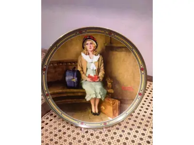 LOTE 292 - 01 PRATO DE PORCELANA COLECIONÁVEL. ASSINATURA KNOWLES 1985 NOME EM PORCELANA FINA DA EDIÇÃO LIMITADA "ROCKWELL'S AMERICAN DREAM" DE 1985. A PLACA TEM SEU PRÓPRIO NÚMERO INDIVIDUAL NA SÉRIE 4716C  E UM NÚMERO NA LISTA INTERNACIONAL DE PLACAS DE COLECIONADOR BRADEX N.º 84 - R70 - 7. 1 COM DECORAÇÃO DE NORMAN ROCKWELL. TEMA  'O SONHO DE UMA JOVEM'. O PRIMEIRO DA SÉRIE AUTORIZADO PELA FAMÍLIA DO AUTOR.PORCELANA FORTE, NOBRE E RESSONANTE. FORMATO LEVEMENTE SEMI PROFUNDO, DECORAÇÃO PICTÓRICA CHARMOSA COM ACABAMENTO ACETINADO. CORES INTERESSANTES BORDA DOURADA. ASSINATURA DO AUTOR NO ANVERSO E NO REVERSO. PARA DECORAÇÃO, COM 21 CM DE DIAMETRO COM CAIXA CERTIFICADO DE AUTENTICIDADE E FOLHETOS ORIGINAIS. (NO ESTADO) ATENÇÃO! FAZER A VISITAÇÃO ANTES DE ARREMATAR, NÃO SABEMOS SE FUNCIONA, LEILÃO NÃO TEM GARANTIA E NEM DEVOLUÇÃO, SUJEITO A POSSÍVEIS AVARIAS VISÍVEIS/OCULTAS E/OU AUSÊNCIA DE COMPONENTES.