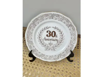 01 PRATO COMEMORAÇÃO DE ANIVERSÁRIO 30 ANOS COM 19 CM DE DIÂMETRO  BORDAS A BANHO A OURO IMPORTADO JAPÃO, SUPORTE DO PRATO NÃO ESTÁ INCLUÍDO. ITEM COMPRADO EM GARAGENS DE ANTIGUIDADES NOS EUA. (NO ESTADO) ATENÇÃO! FAZER A VISITAÇÃO ANTES DE ARREMATAR, NÃO SABEMOS SE FUNCIONA, LEILÃO NÃO TEM GARANTIA E NEM DEVOLUÇÃO, SUJEITO A POSSÍVEIS AVARIAS VISÍVEIS/OCULTAS E/OU AUSÊNCIA DE COMPONENTES.